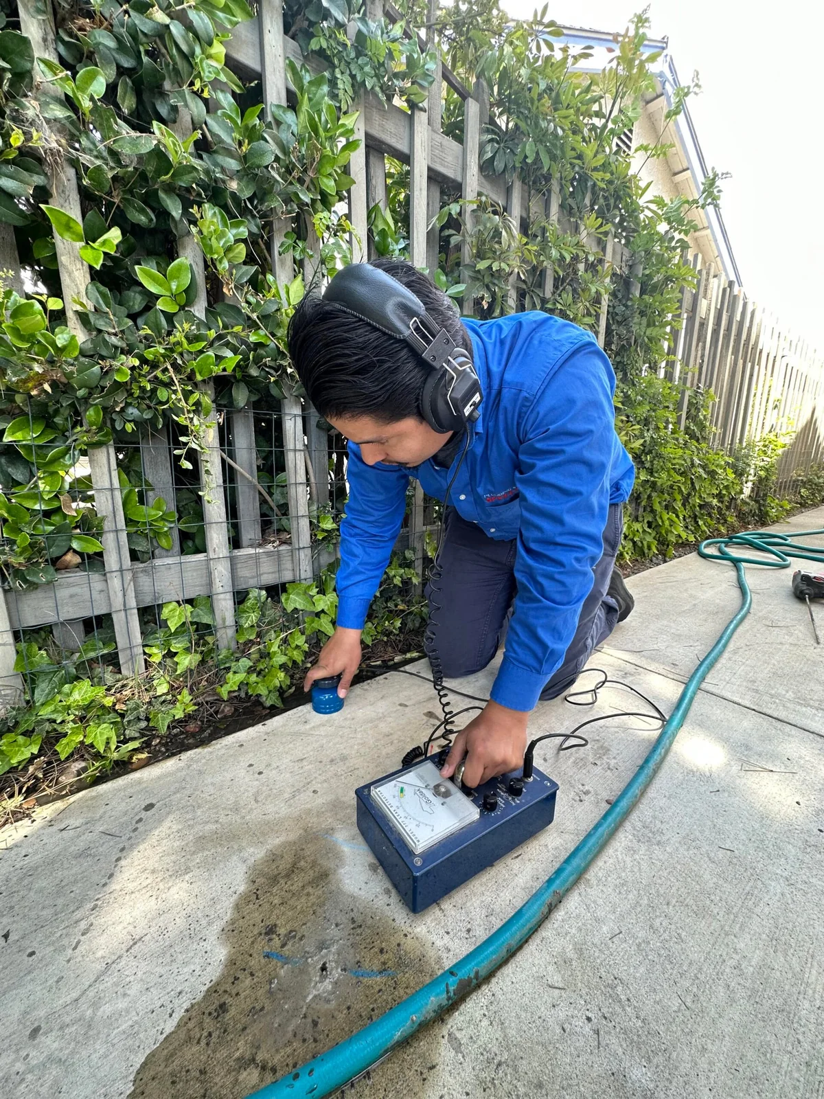 Technician using electronic equipment to investigate a possible water leak